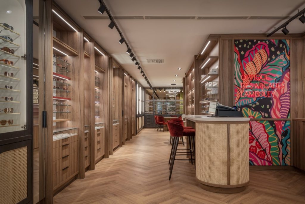 Winkelinterieur van opticien in Zwitserland met centrale rotan balie en wandpresentaties voor brillen