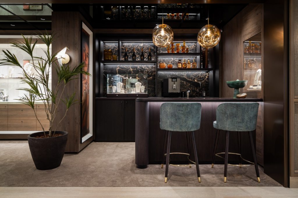 Maatwerk koffiebar met ingebouwde vitrine en luxe barstoelen